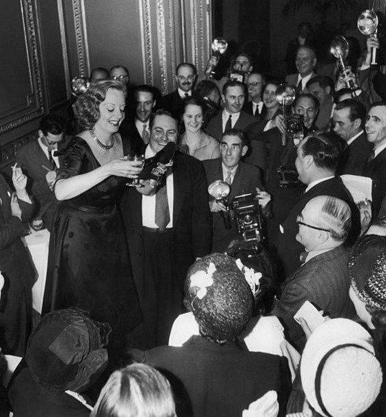Tallulah Bankhead drinking champagne from her shoe during a press conference at the Ritz, London, 1951